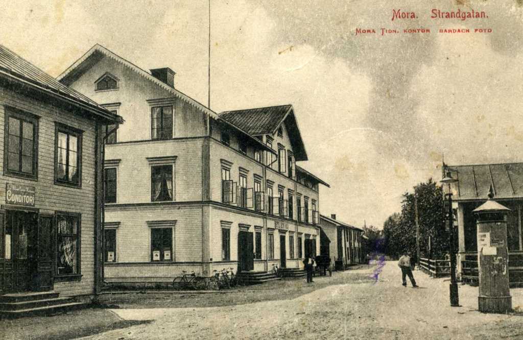 Fin bild med affischpelaren och B Hallgrens ateljé på Strandgatan. Conditori till vänster.